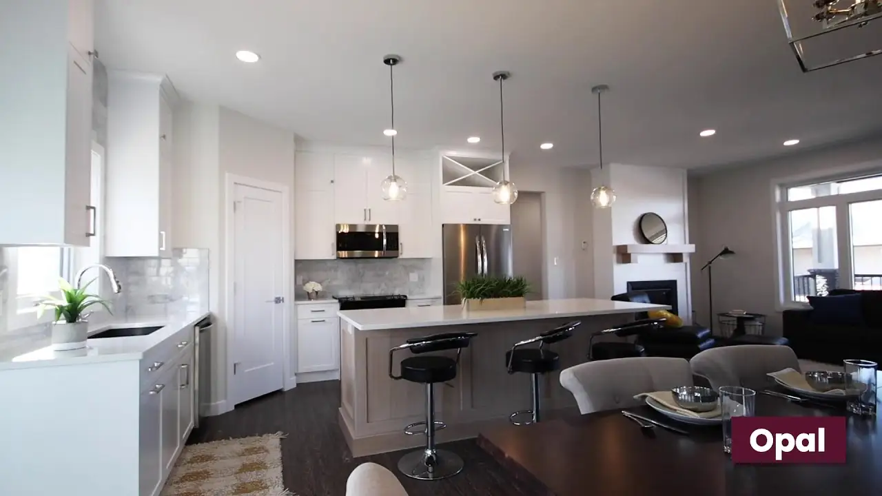Bright modern kitchen featuring white custom cabinets, a large wood-accent island, and sleek built-in storage crafted by Hiebert Cabinets.