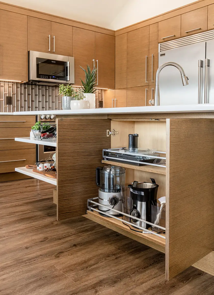 Custom kitchen cabinetry with pull-out storage drawers and built-in appliance organizers, showcasing premium woodwork and modern cabinet design by Hiebert Cabinets.