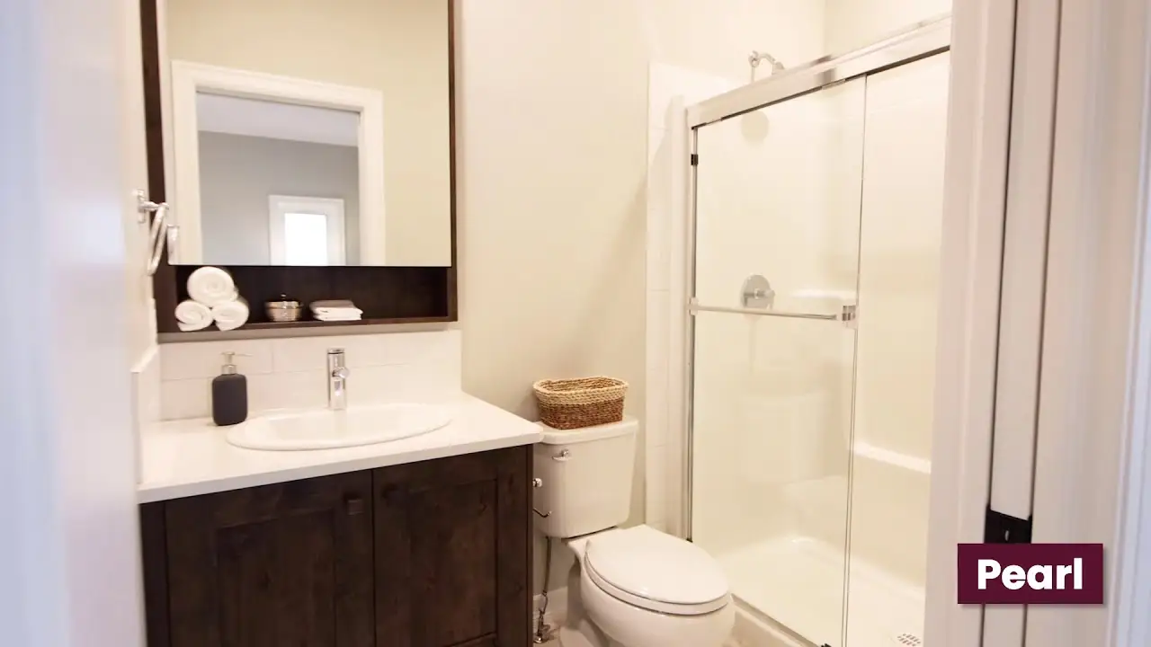 Bathroom with custom dark wood vanity cabinetry, integrated mirror shelf, and clean modern finishes crafted by Hiebert Cabinets.