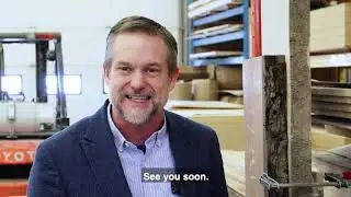 John Hiebert standing in a custom woodworking shop surrounded by lumber and equipment, highlighting the craftsmanship behind Hiebert Cabinets.