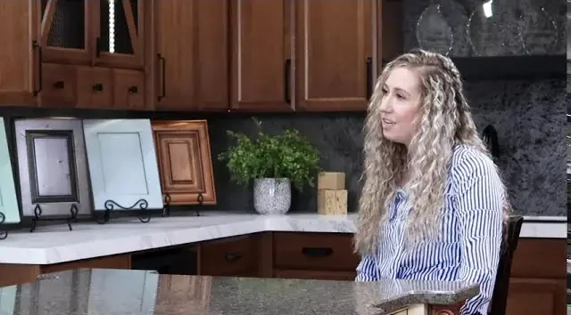 “Showroom with custom cabinet door samples displayed on a countertop, showcasing Hiebert Cabinets’ woodwork and finish options during a client design consultation.